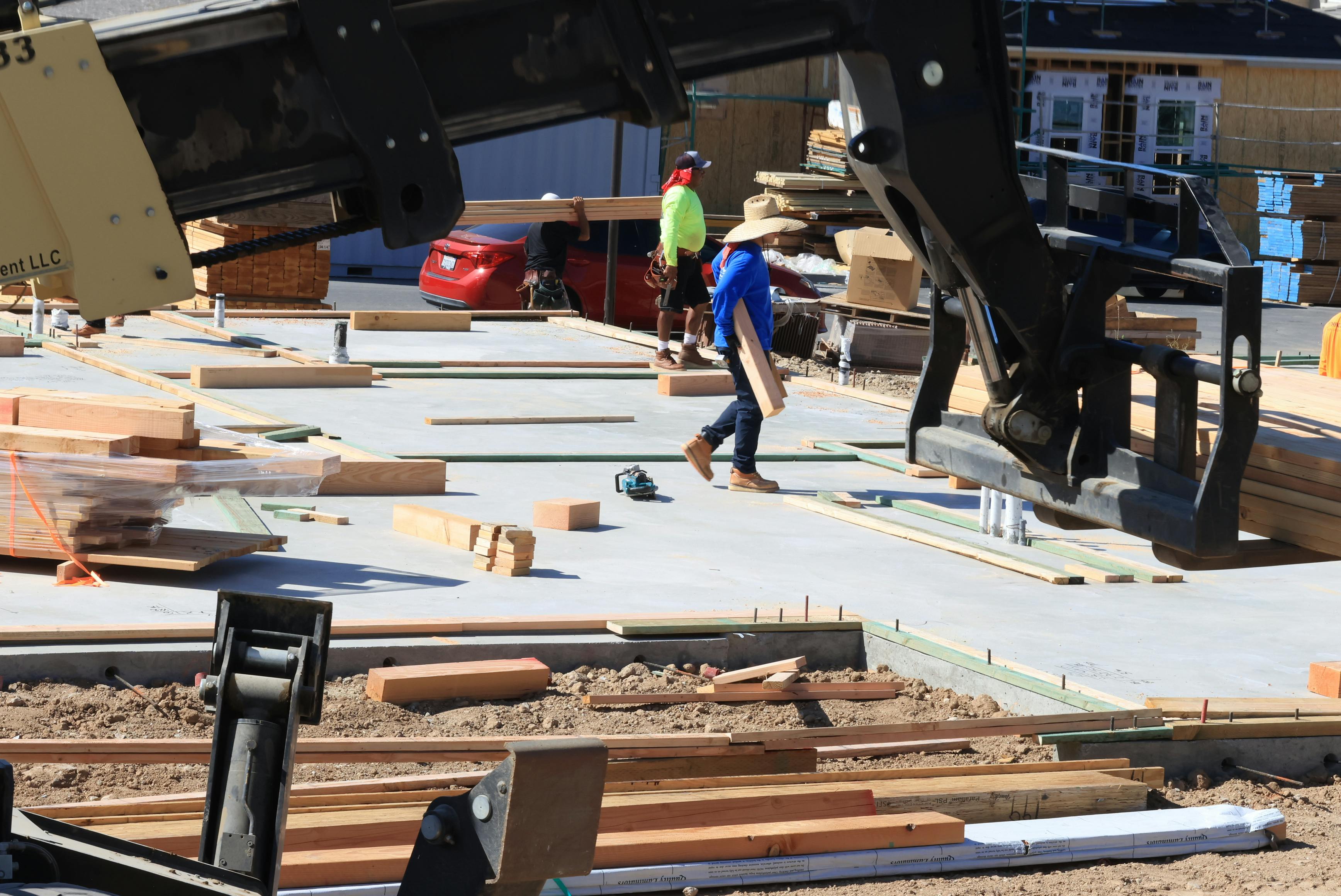 General carpenters handling and installing timber components on a large construction project.